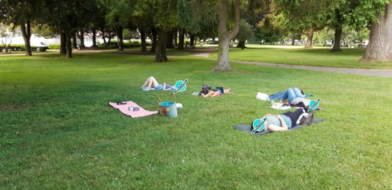 Photo illustrative d'un groupe de personnes allongées dans l'herbe pendant la séance de relaxation