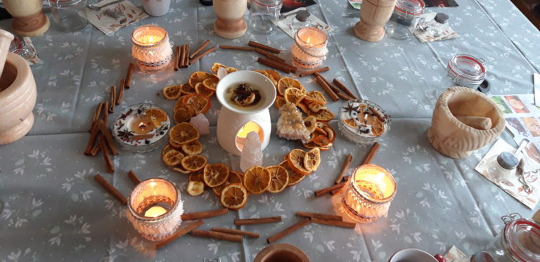Photo de la décoration de la table lors de l'atelier avec des bougies, fruits secs et bâtons de canelle
